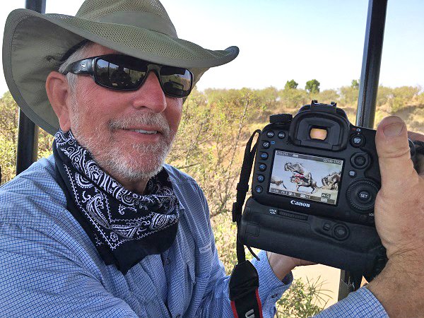 Safari photographer shows off his photo of the wildebeest crossing the Mara River in East Africa