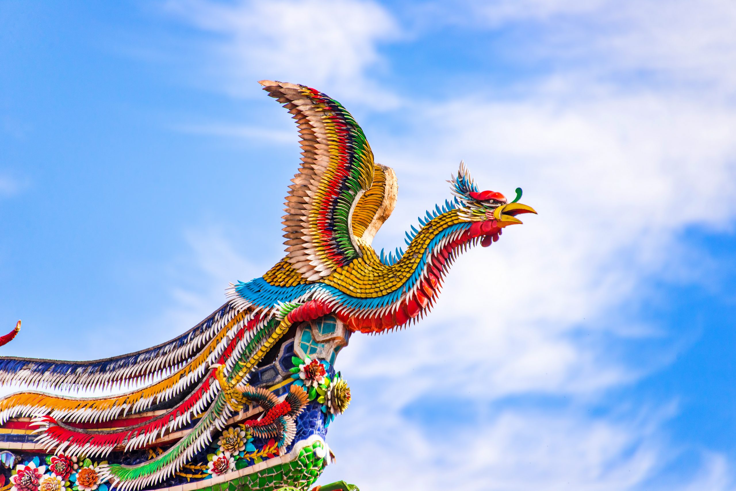 Beautiful Phoenix flying on the decorative tile roof in Chinese temples. Colorful roof detail of traditional Chinese temple