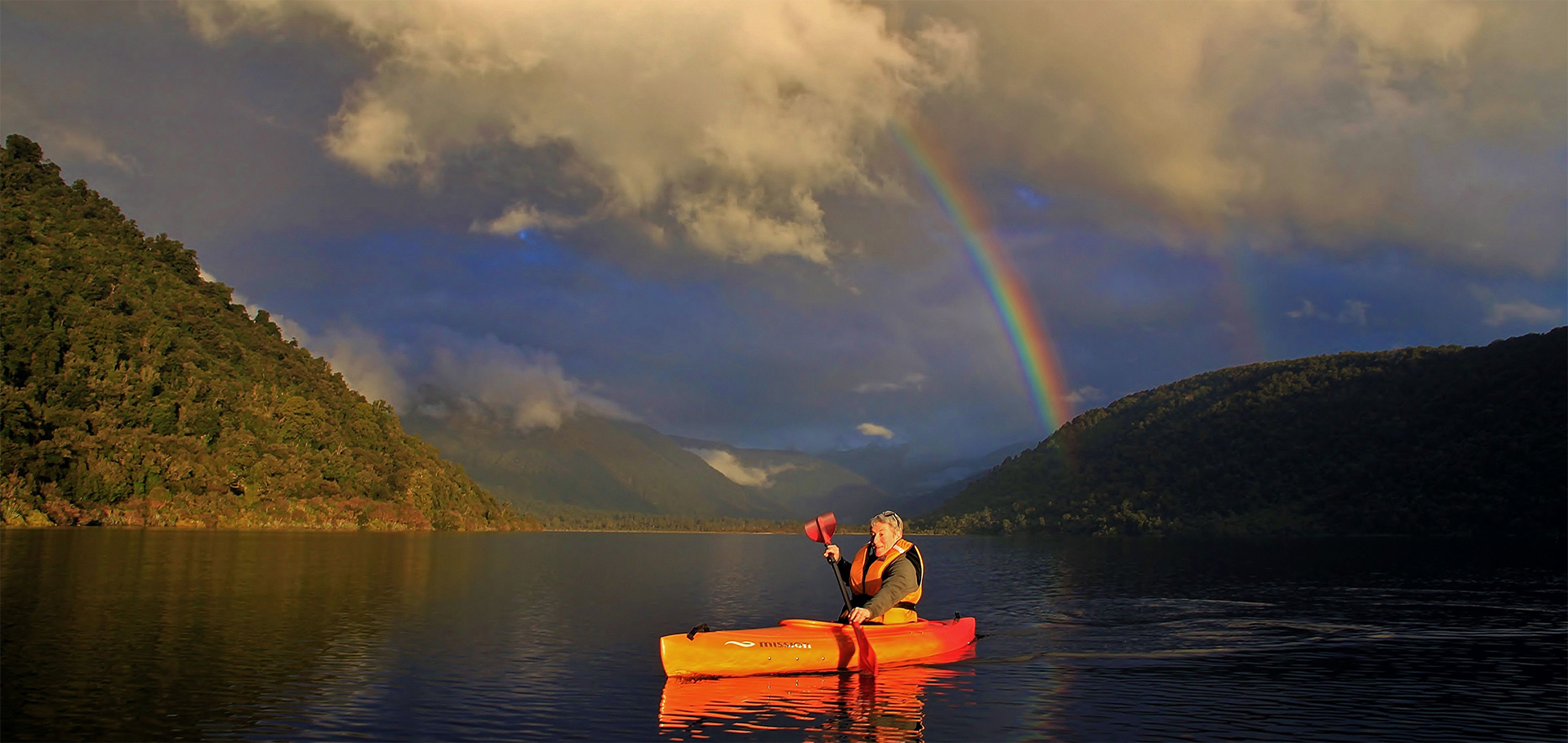 Woman solo traveler kayaking in New Zealand Lake Moeraki New Zealand