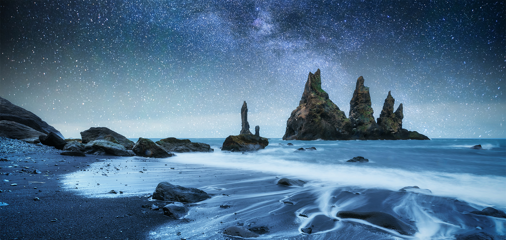 The Rock Troll Toes. Reynisdrangar cliffs. Black sand beach. Iceland. Fantastic starry sky and the milky way.