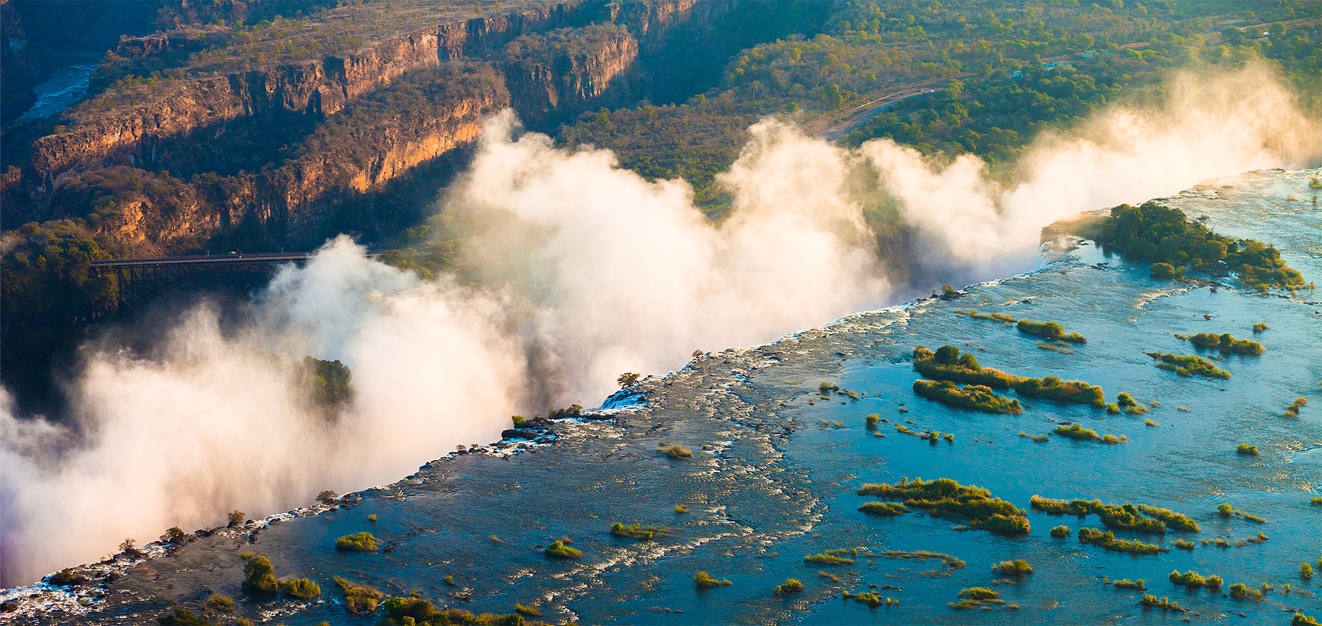 Victoria falls Zimbabwe Southern Africa green landscape thundering clouds wall of rushing water river