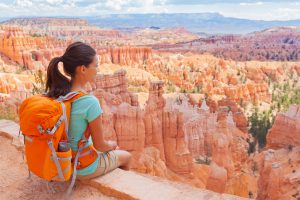 USA Hiker woman in Bryce Canyon hiking relaxing looking at view during hike wearing backpack on summer travel. Bryce Canyon National Park landscape, Utah, United States.