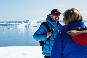 Smiling and laughing Nat Hab & WWF Expedition Leader teaches travelers about climate change and wildlife in Antarctica