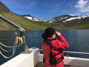 Woman with binoculars on boat ride in Iceland