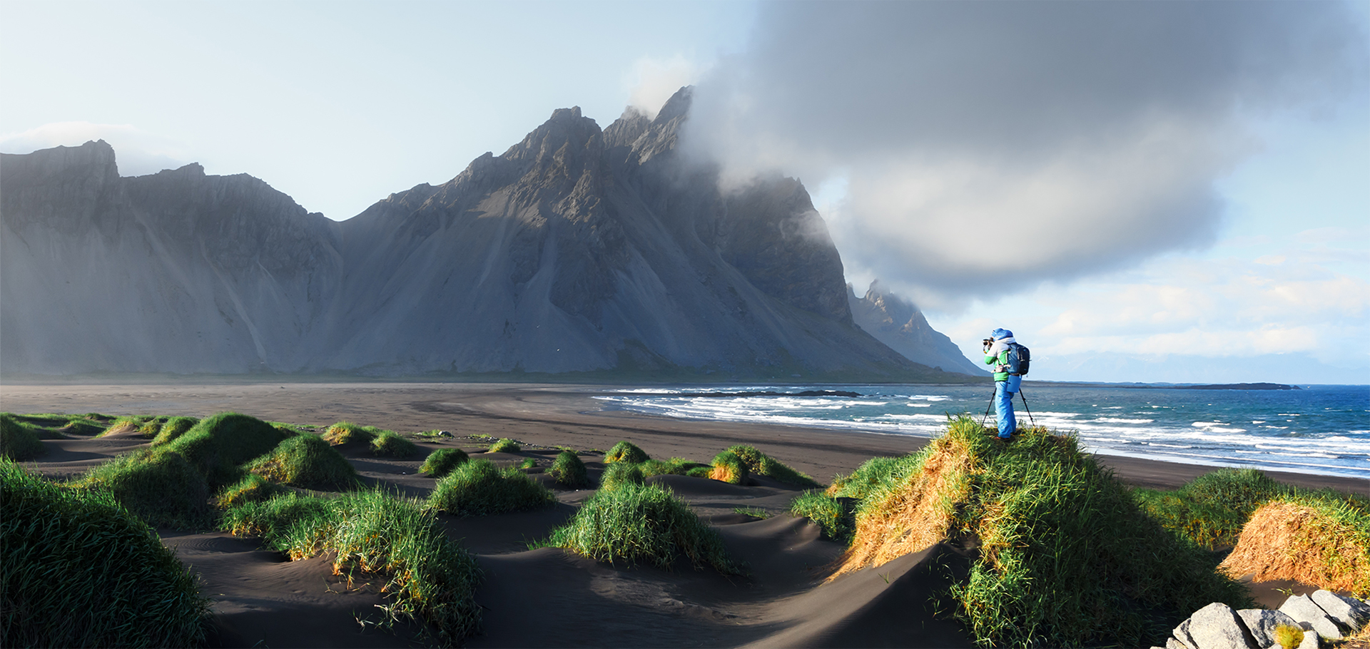 Photographer taking photo of famous grass hills near Stokksnes mountains, Iceland