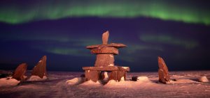 Inukshuk under the northern lights in Churchill, Manitoba