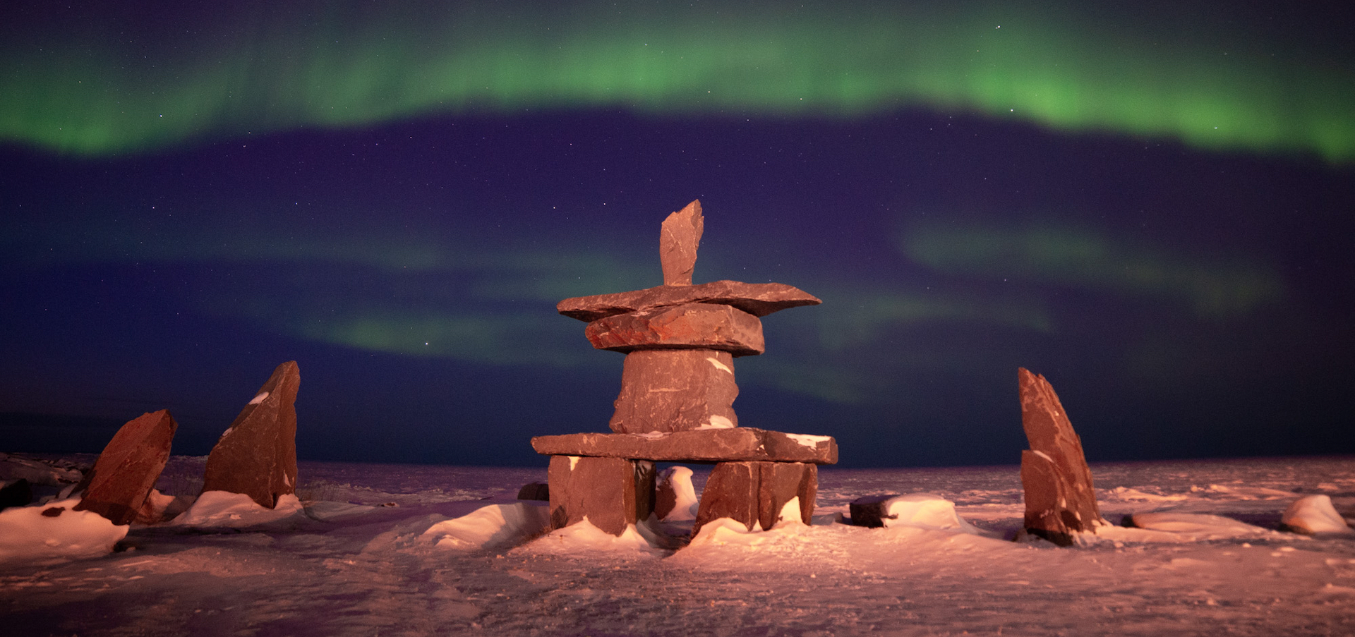 Inukshuk under the northern lights in Churchill, Manitoba