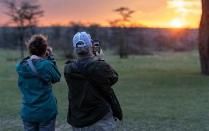 Nat Hab guests photograph the sunset, Mara East Camp—Mara Conservancy