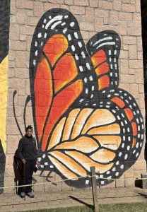 Woman in front of a monarch butterfly mural in Mexico