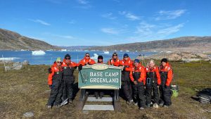 Group of travelers with Nat Hab base camp Greenland sign