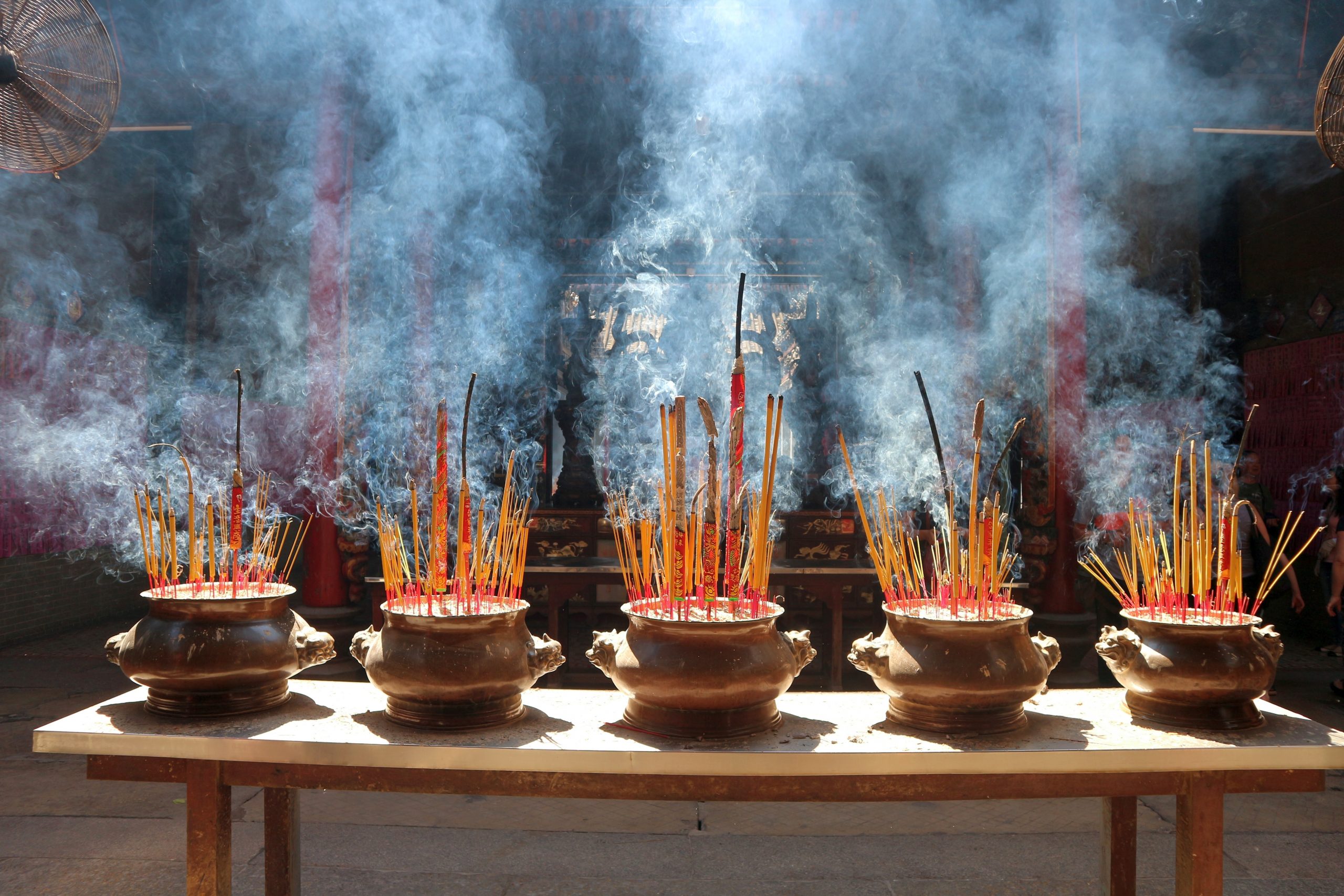 Temple with incense smoke from bowls on table in Ho Chi Minh in Vietnam