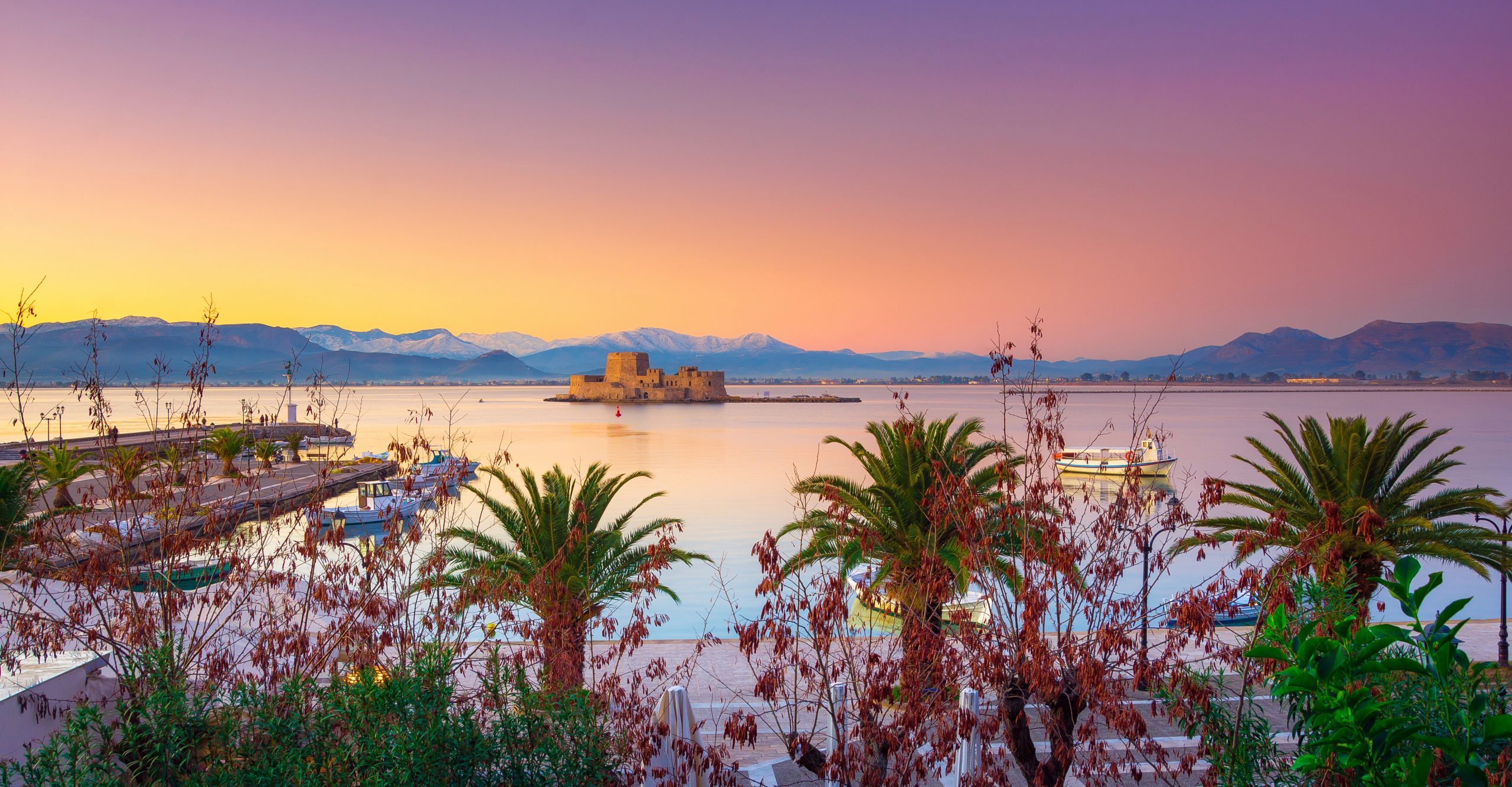 Beautiful port of Nafplio city in Greece with small boats, palm