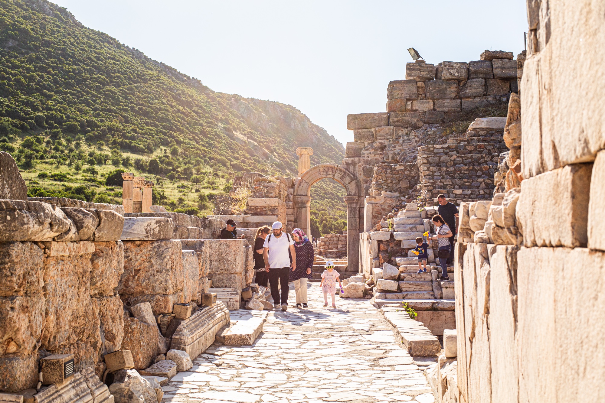 Travelers walk through the ancient ruins of Ephesus